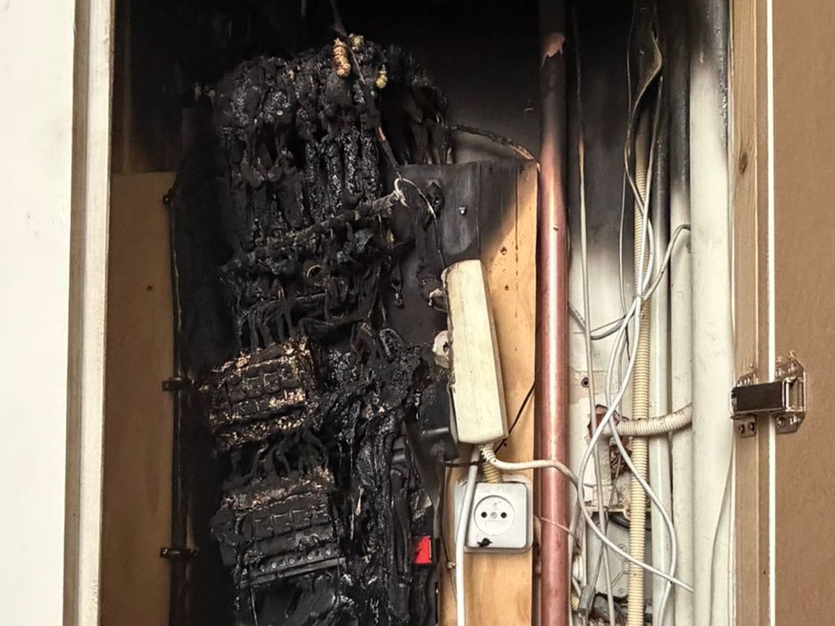Een weggebrande groepenkast in een open meterkast: gesmolten bedrading en zwartgeblakerde automaten